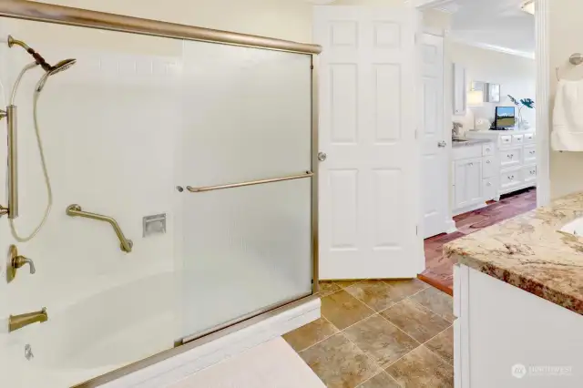 Soaking tub and shower with glass surround.