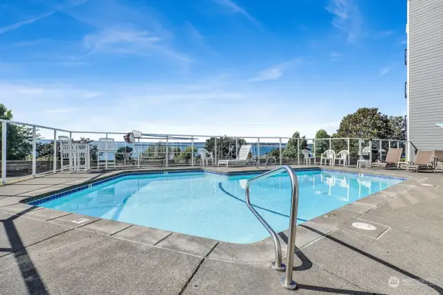 Seasonal heated swimming pool with glass surround and lounging furniture with Bellingham Bay views.