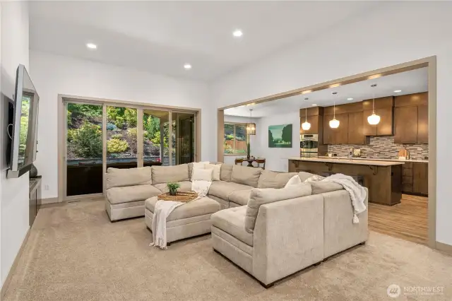 As you continue into the home, you'll be wowed by the stunning custom living, kitchen, and dining area