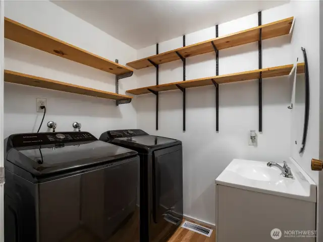 The utility room is spacious includes a convenient sink and affers lots of storage options.
