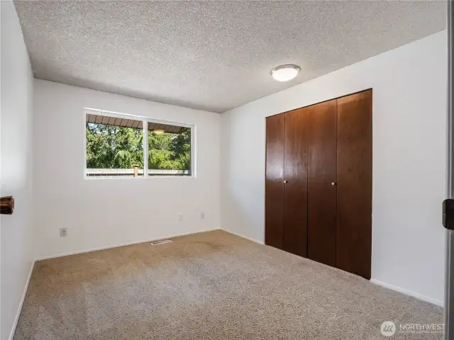 The first of the bedrooms looks out over the home's side yard.