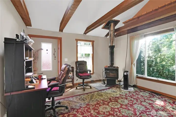 living room off original entrance to home with freestanding wood stove