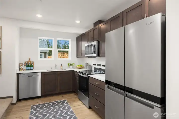 Contemporary kitchen features sleek finishes, stainless appliances, and quartz countertops.
