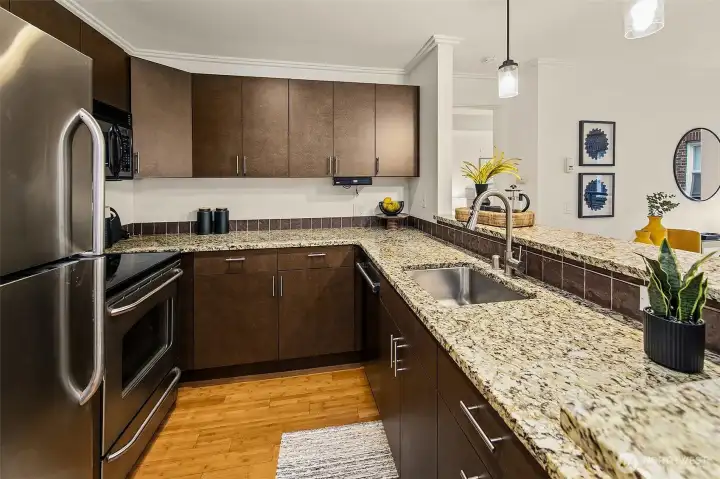 Wrap-around kitchen allows for ample storage & prep space on granite counters. High bar eating area is a great place to host and eat.