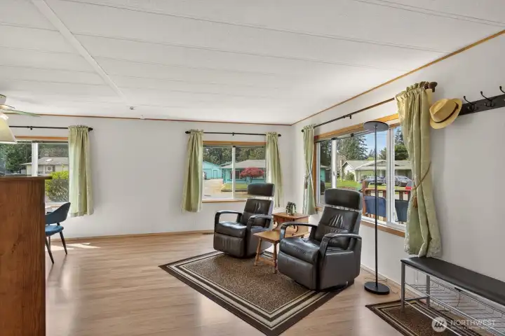 Bright, window-lined living room filled with abundant natural light.