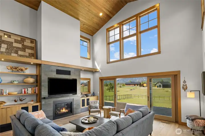 A stunning great room featuring custom built-in cabinets & shelving, complemented by sliding French doors that open to expansive outdoor living space.