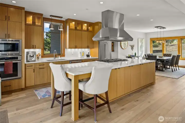 Kitchen featuring premium appliances, ample counter space, and an eating island, with an adjacent dining area ideal for everyday meals and entertaining.