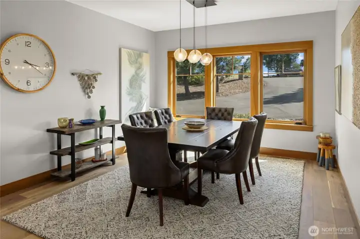 Dining area filled with natural light from surrounding windows, offering a peaceful and inviting setting..