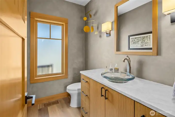 Half bath featuring quartz countertops and abundant natural light, creating a bright and airy feel.