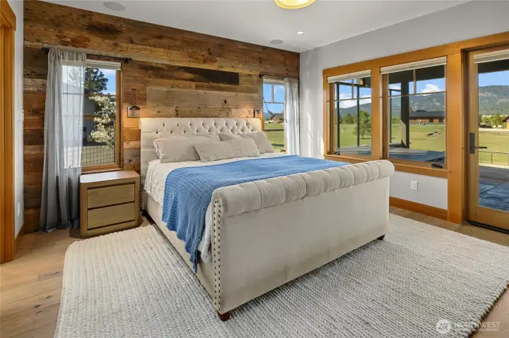 Primary bedroom featuring a spacious walk-in closet and direct access to outdoor living areas, perfect for enjoying the hot tub or relaxing by the firepit.