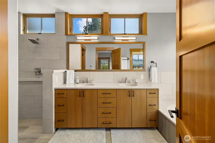 Spa-like primary bath featuring heated floors, dual sinks, dual shower heads, and a soaking tub for ultimate relaxation.