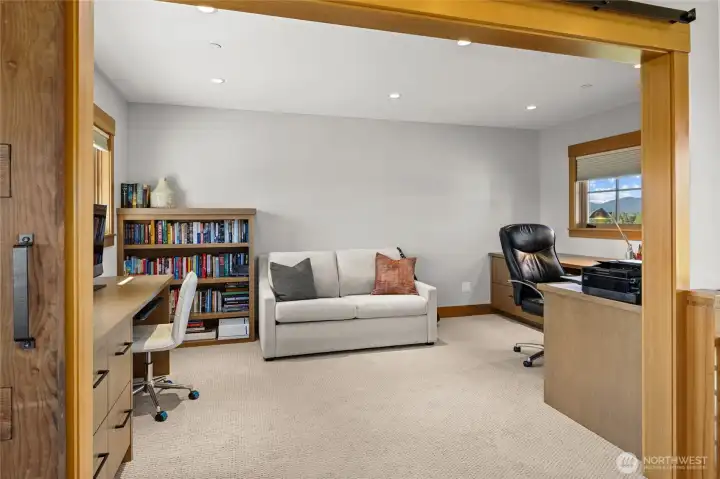 Upstairs office featuring built-in cabinets, with flexible use as additional space for guests when needed..