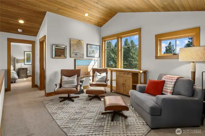 Upstairs loft seating area filled with natural light, offering a bright and comfortable space to relax.
