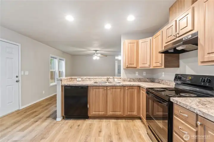 Bright kitchen with ample cabinetry and natural light, open to the living area.
