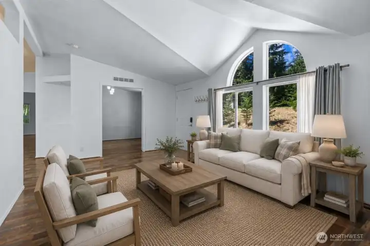 Large windows frame peaceful views of the surrounding greenery while creating a bright and inviting atmosphere. Whether hosting guests or enjoying a quiet evening at home, this central gathering space feels warm, comfortable, and connected. [Photo is virtually staged]