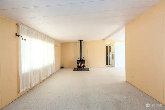 Large living room with free standing propane stove.
