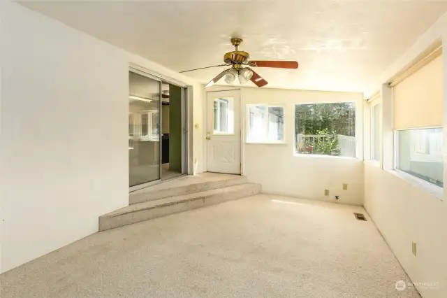 Enclosed sunroom has ceiling fan and floor vents for heat and air conditioning. Sliding door to kitchen.