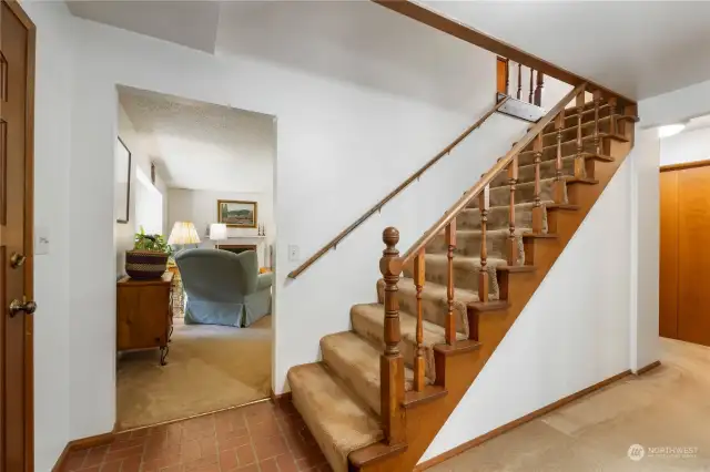 Stairs up. And behind the photographer is a bedroom/den. Hallway you see wraps around into the dining room.