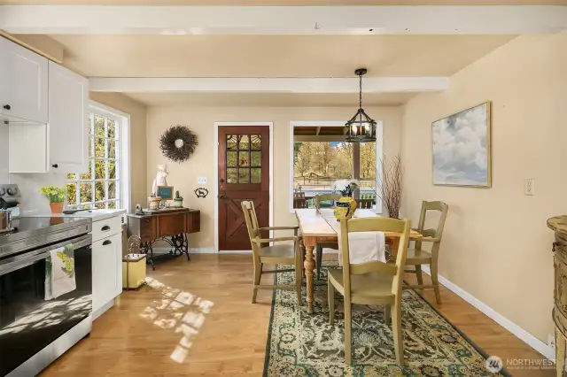 View of kitchen to back porch which overlooks the property and private fenced yard space.