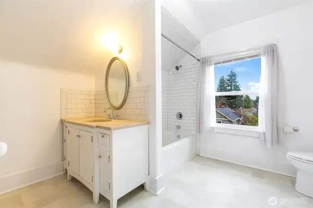 Totally remodeled bathroom with large vanity with stone counter top and a full bath fully tiled.