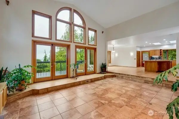 Open concept great room with the kitchen and dining space as well as double doors to access the large deck.