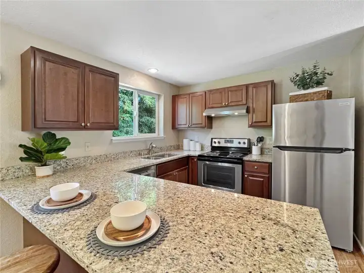 The main floor boasts a recently updated kitchen, featuring durable granite countertops and a stylish set of stainless steel appliances, creating a functional and attractive space for culinary endeavors and everyday living.