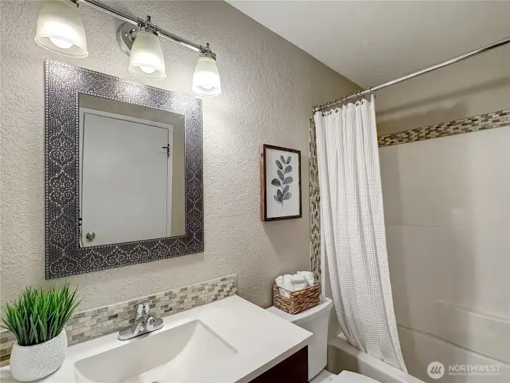 This main floor bathroom offers exceptional convenience, being directly adjacent to the Primary Bedroom and thoughtfully designed to comfortably accommodate guests during their stay.