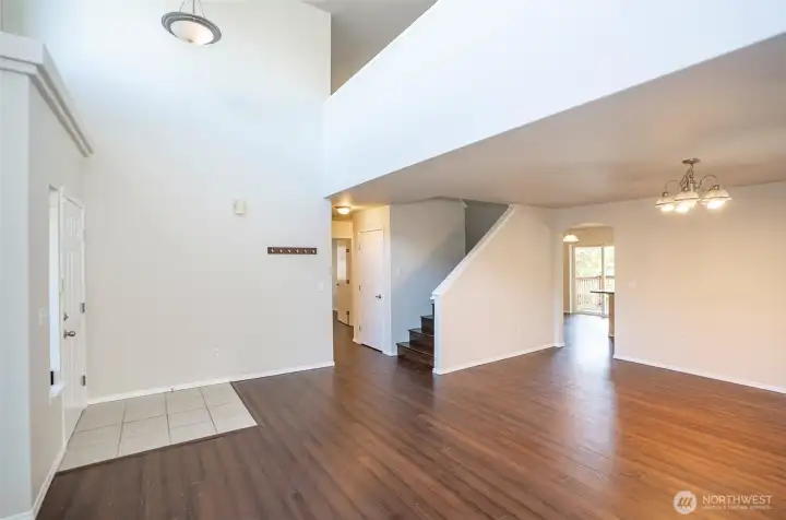 Spacious and inviting living area featuring stunning hardwood floors and a soaring vaulted ceiling.