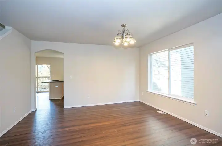 The dining area offers a view into the kitchen and is enhanced by a striking, oversized picture window that floods the space with natural light.