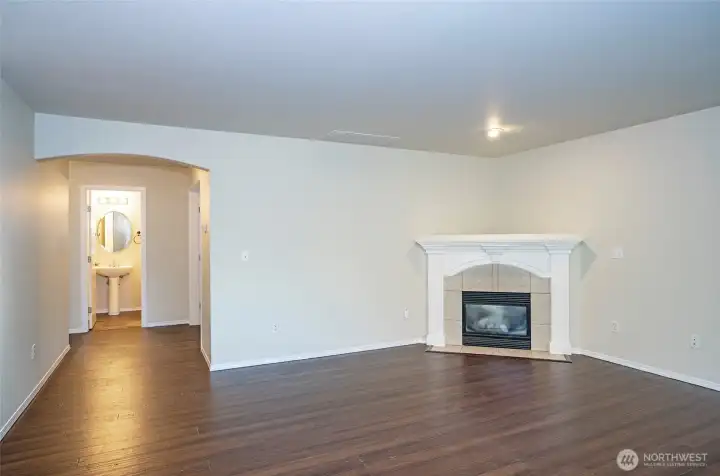 Family room showcasing a cozy gas fireplace and beautiful hardwood floors.