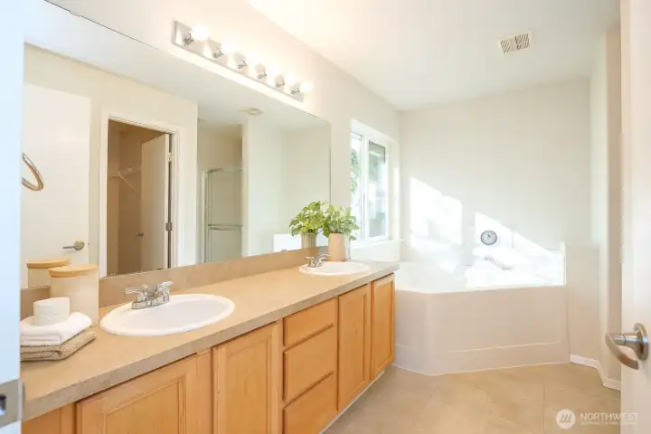 The primary ensuite boasts dual sinks and a relaxing soaking tub, with a walk-in shower and water closet conveniently located just around the corner - Virtually staged to inspire your vision of the space.