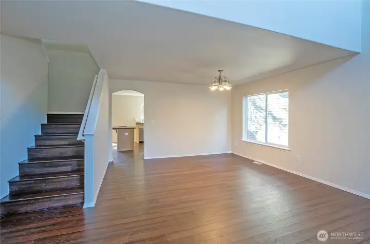 The dining area sits adjacent to a staircase on the left, leading up to the upper level.