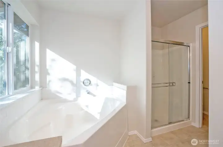 The primary ensuite offers a luxurious soaking tub and a walk-in shower, with a private water closet conveniently located just beside the shower.