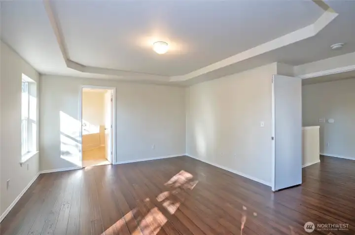 Primary suite with a view toward the entrance of the luxurious five-piece ensuite.