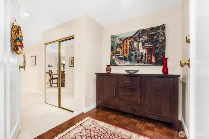 Entry hall with parquet flooring opens to the living and dining areas beyond.