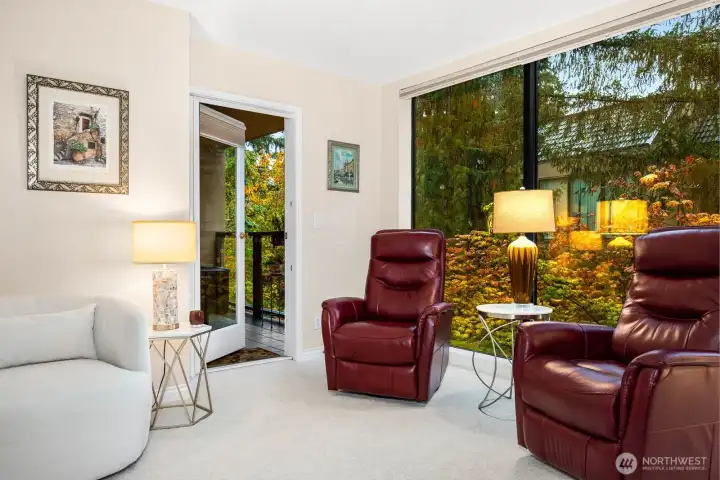 The living room’s picture windows create a serene backdrop of Northwest greenery.