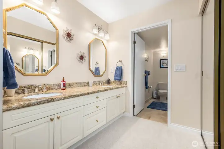 Ensuite bathroom with granite dual-sink vanity, soft lighting, and ample storage.