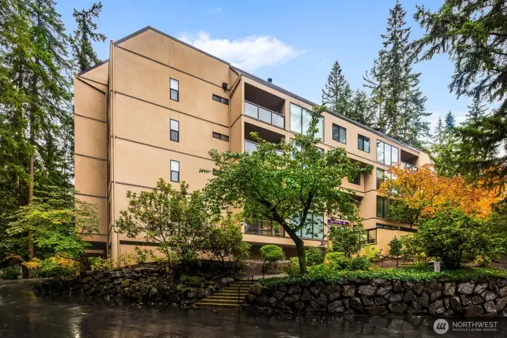 Alternate exterior view highlighting the modern stucco façade and seasonal foliage.