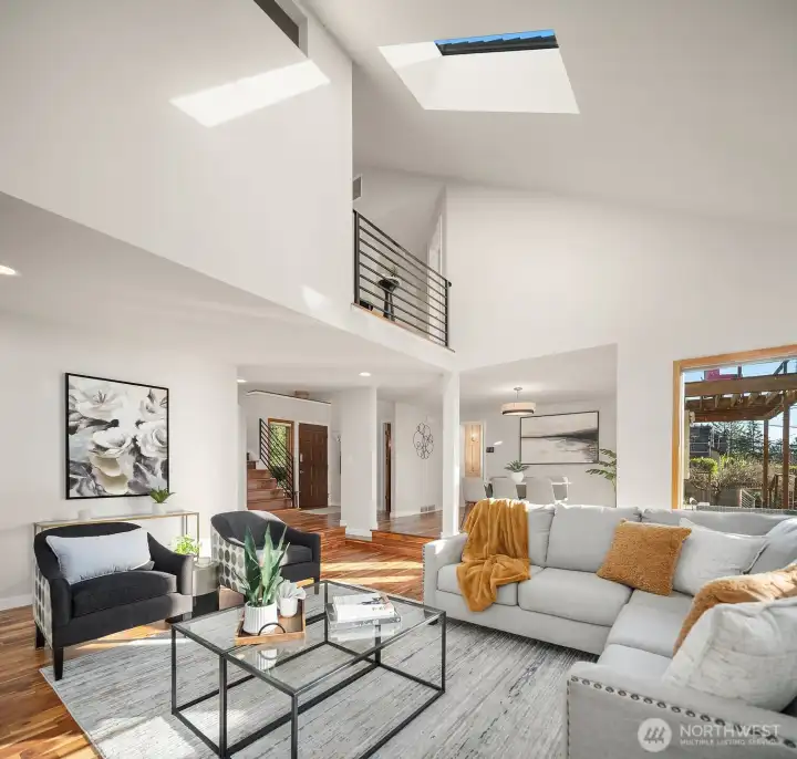 Another angle of the main living area to the vaulted ceilings and a view of the second floor. To the left of the stairs is an extra room which could be a 4th bedroom, home office, gym, or studio.