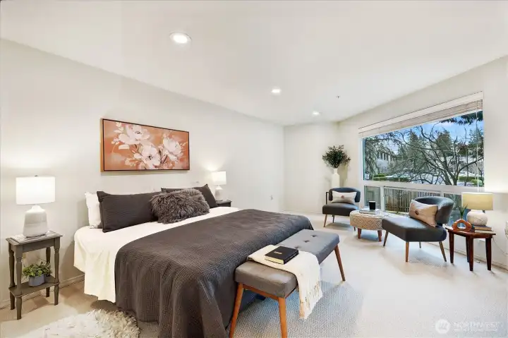 Enormous primary suite with large picture window and lots of extra space for a sitting area or home office.