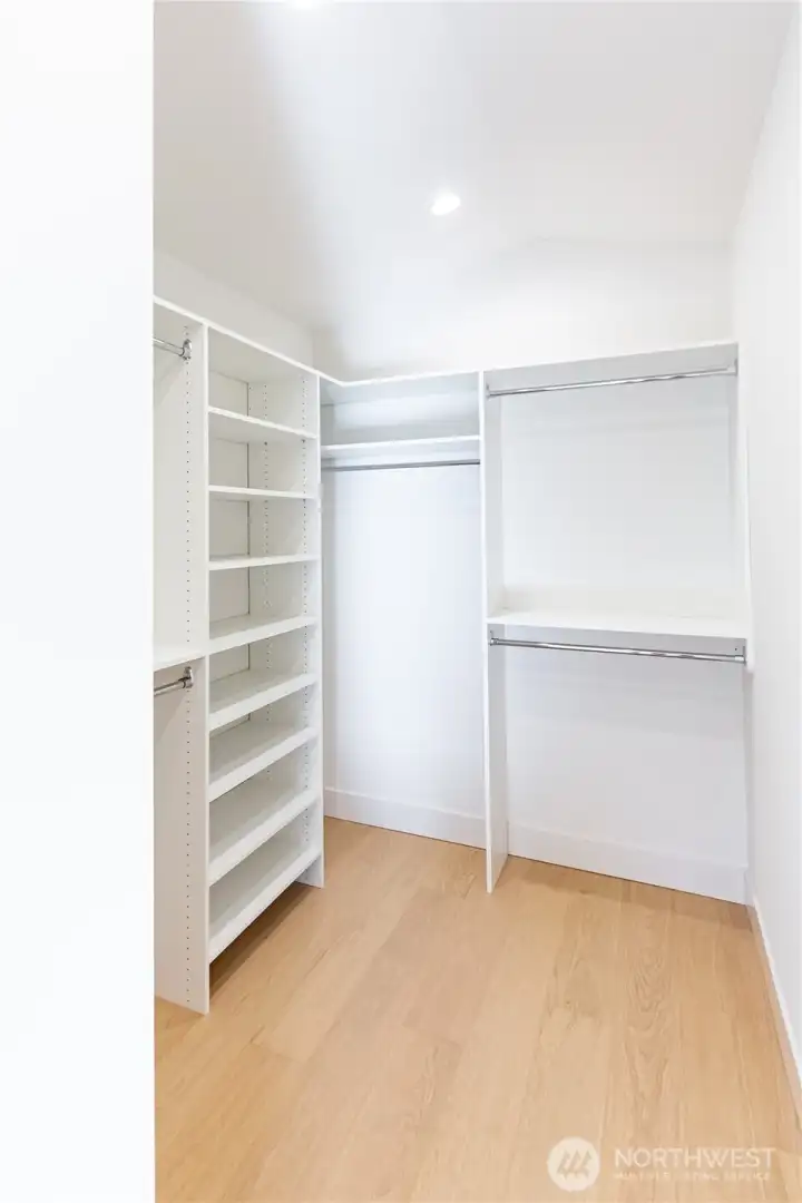Primary bedroom walk in closet with closet system installed Primary bedroom walk in closet with closet system installed