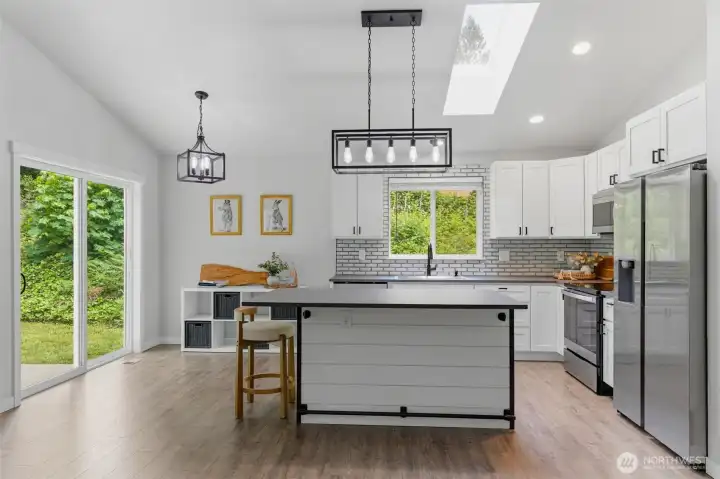 Bright and full of light. The kitchen flows beautifully into the dining space, where sliding glass doors invite the peaceful PNW outdoors in.