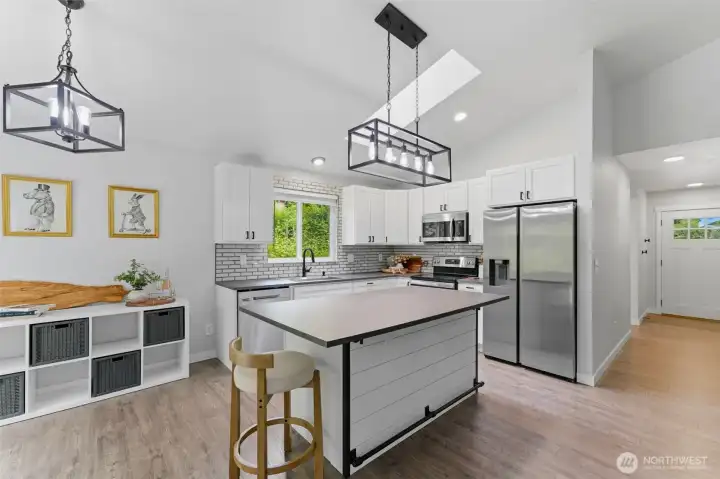 ruly the centerpiece of the home. Modern glass tile backsplash, crisp shaker cabinetry, and gleaming stainless steel appliances make this kitchen feel brand new.