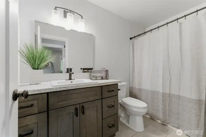 Continuing the home’s signature attention to detail. This guest bath features a bright vanity, stylish fixtures, and a spotless shower/tub combo.