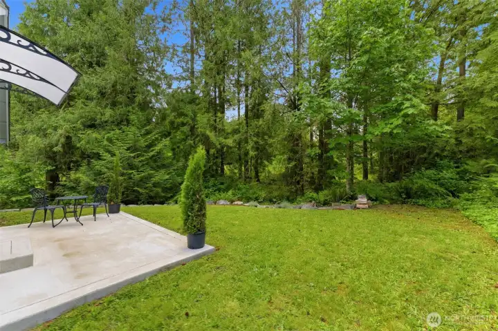 Your private entertainment hub. This beautifully maintained patio overlooks your impeccably manicured lawn and the tranquil, wooded backyard oasis.