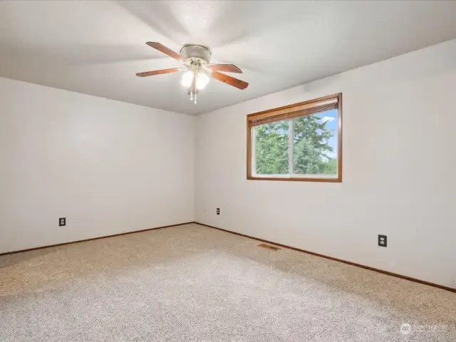 Primary bedroom with attached closet & bathroom features new carpet.