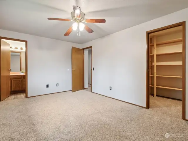 Primary bedroom on main level with attached bathroom and walk-in closet.