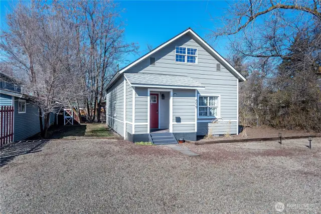 The south side of the home has a grassy area leading to the fenced back yard and little garden shed.