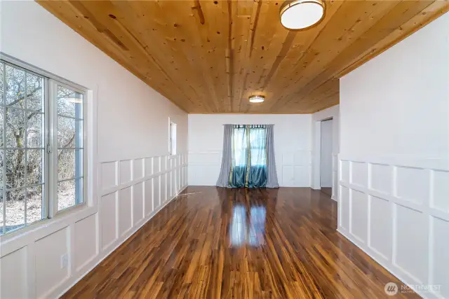 Looking towards the front of the home from the dining and kitchen area full of windows and natural light.