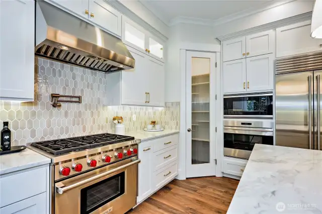 6-burner, gas, Wolf stove with pasta pot faucet and stylish tile backsplash. Large shelved pantry!
